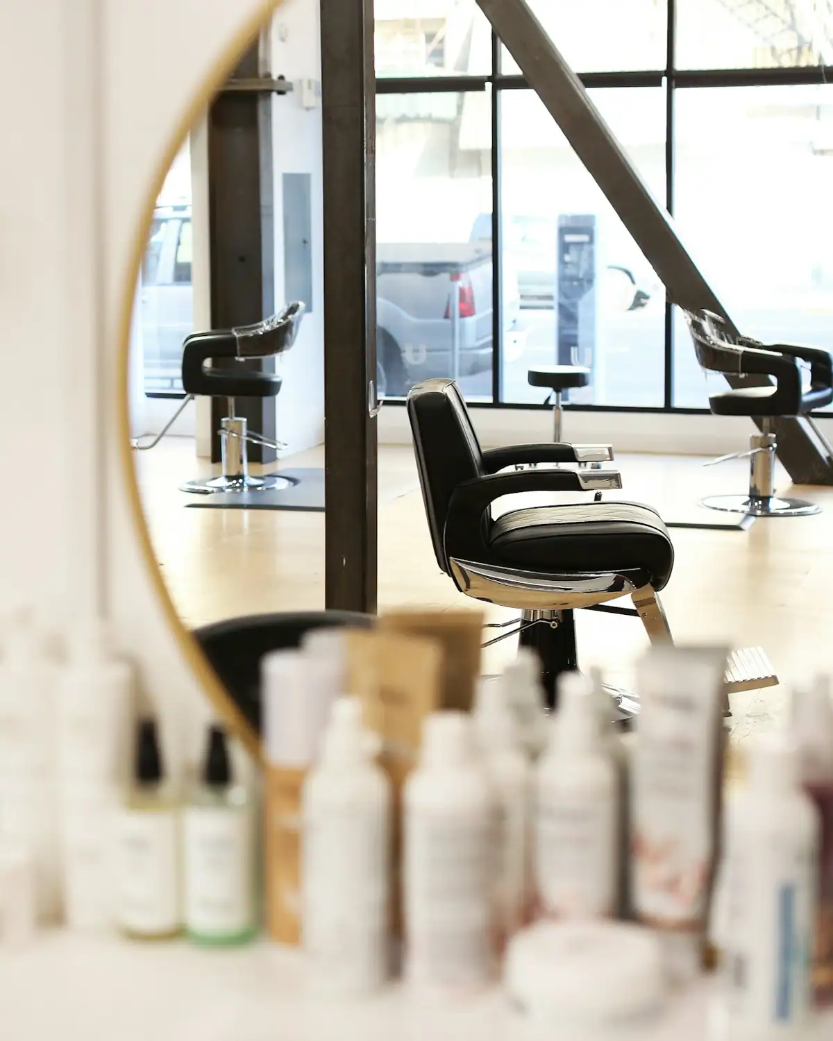 Yuvarlak ayna, saç bakım ürünleri ve salon koltuğu
